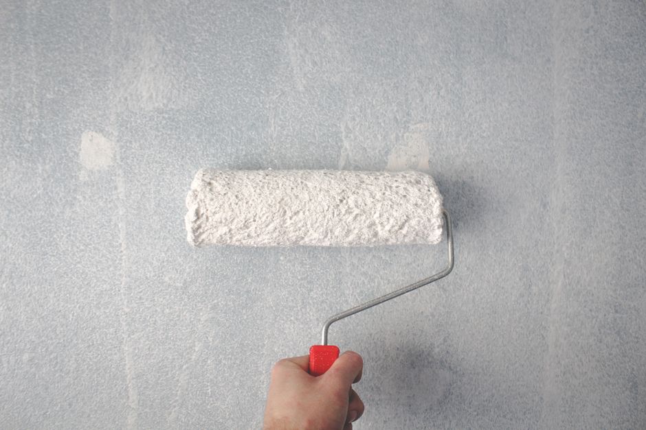 Painter rolling paint onto an interior wall